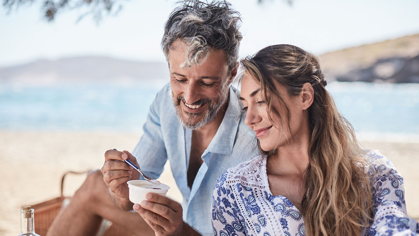 paar stitz im schatten am strand - er löffelt elinas joghurt